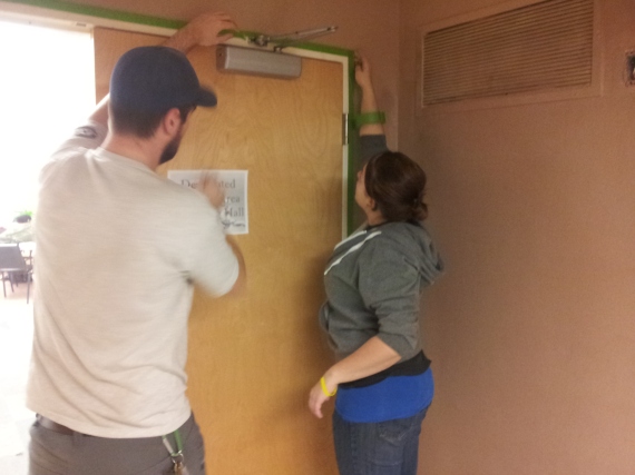 Davis and Amanda taping off a door